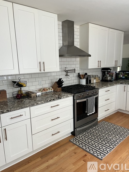 A kitchen with white cabinets and a black stove top oven.