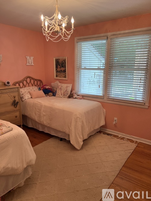 A bedroom with a large bed and a chandelier.