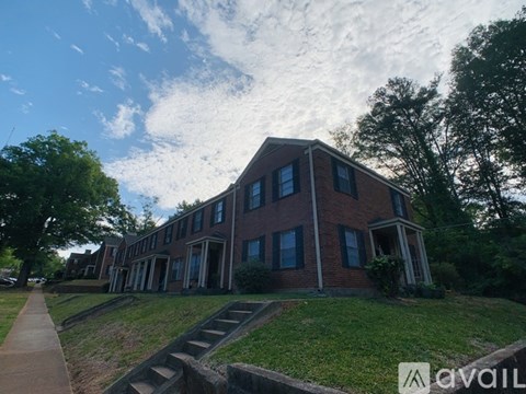 A brick building with a green lawn in front.