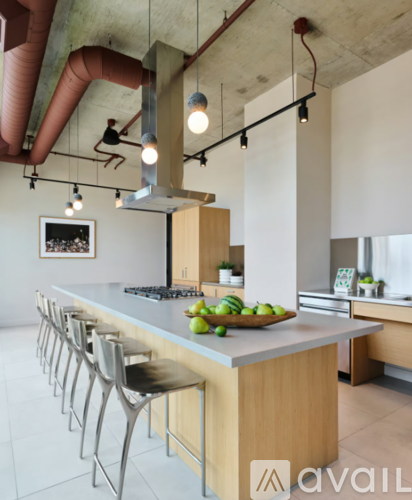 A kitchen with a long counter and chairs.