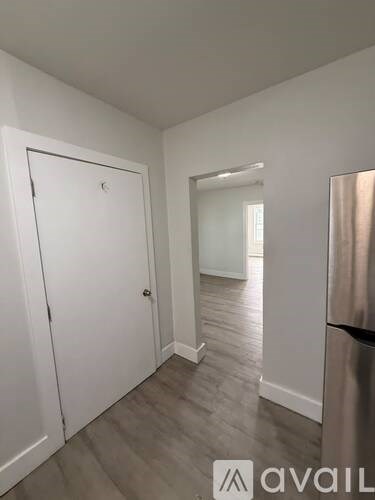 A white door is in a room with a wooden floor.