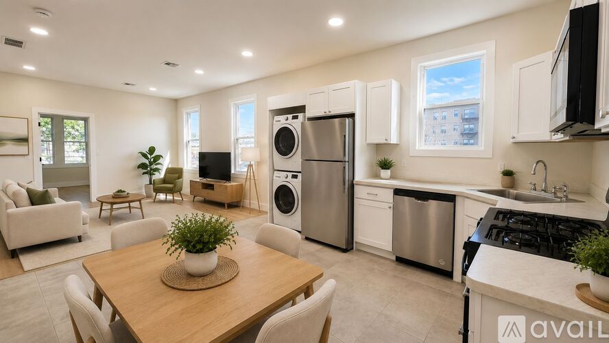 A modern kitchen with stainless steel appliances and a dining table with chairs.