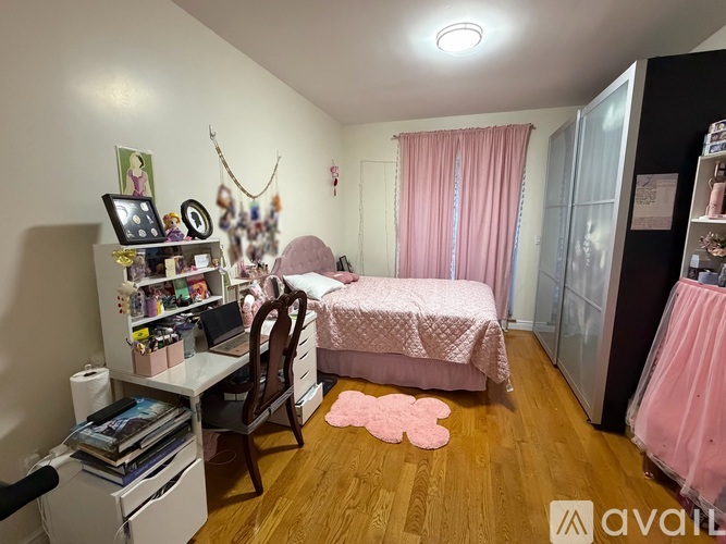 A bedroom with a pink theme and a bed in the center.