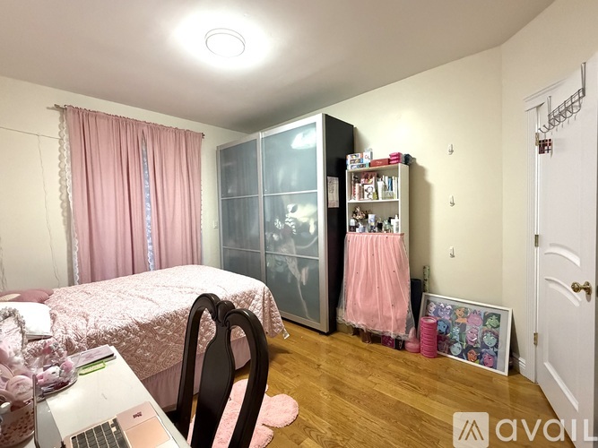 A room with a bed, a desk with a laptop, and a bookshelf.