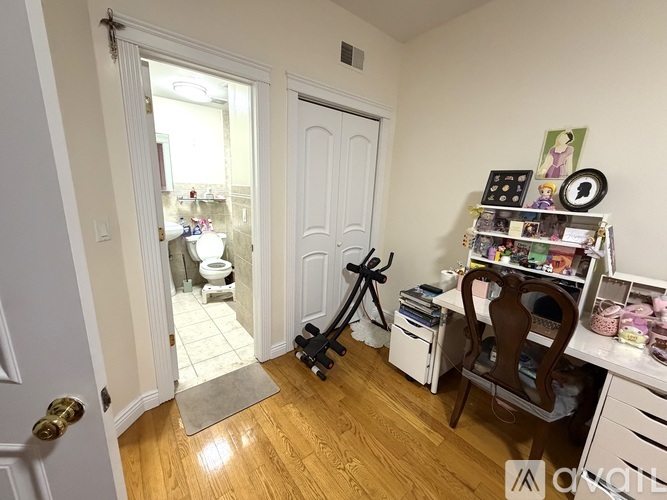 A room with a white door and a desk with a chair.