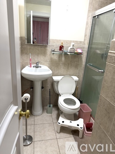 A bathroom with a toilet, sink, and a mirror.