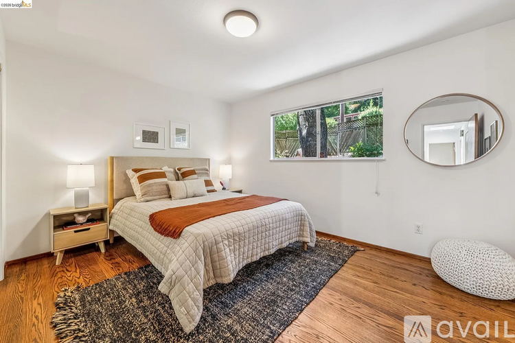 A bedroom with a bed, nightstand, and window.