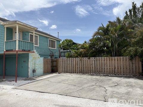 A blue house with a fence and a sign that says "HOUSE FROM THE".