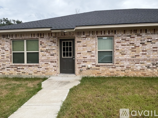 A brick house with a black door and windows.