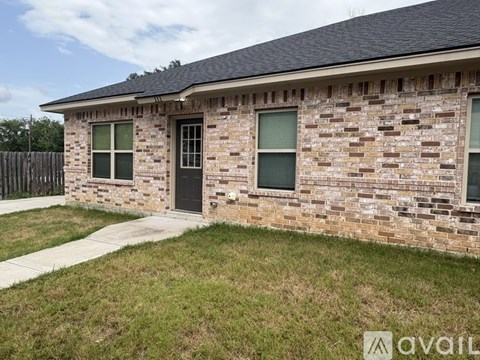 A brick house with a black door and windows.