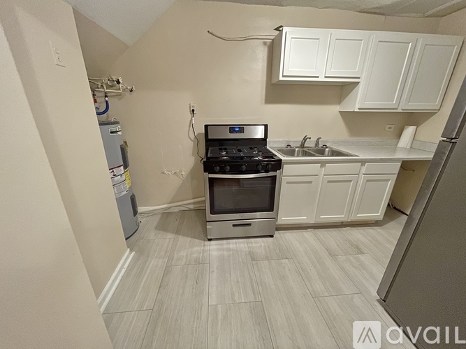 A kitchen with a stove top oven and a sink.