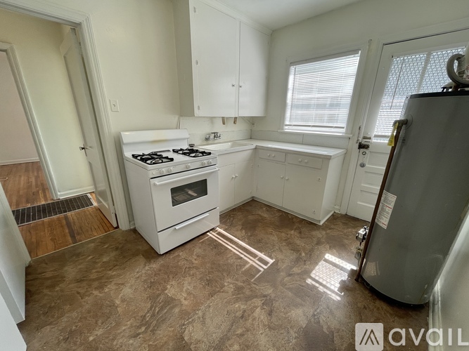 A kitchen with a white stove and a refrigerator.