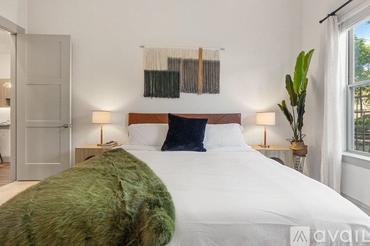 A bedroom with a large bed and a green pillow.