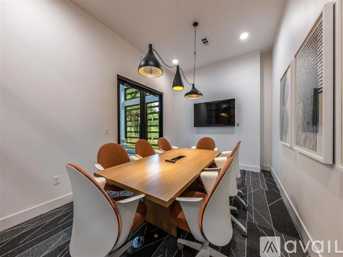 A modern dining room with a wooden table and chairs.