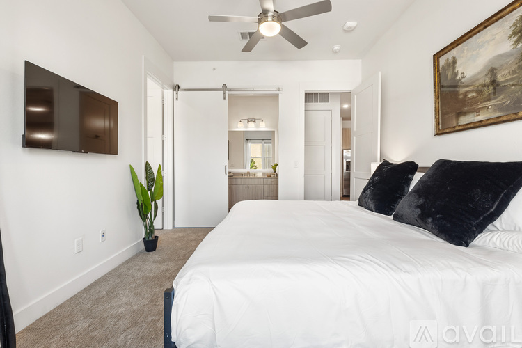 A bedroom with a large bed and a ceiling fan.