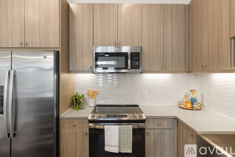 A kitchen with wooden cabinets and a stainless steel refrigerator.