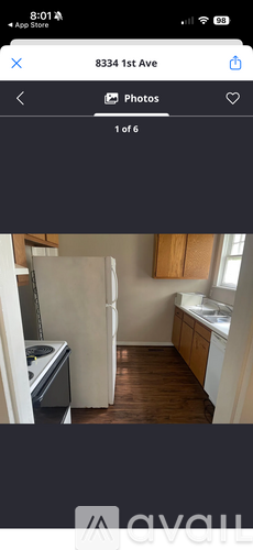 A kitchen with wooden floors and white appliances.