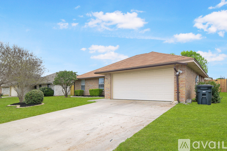 A house with a brown roof and a white garage door is for sale.