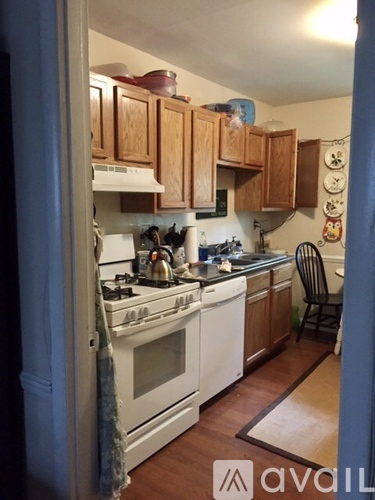 A kitchen with wooden cabinets and white appliances.