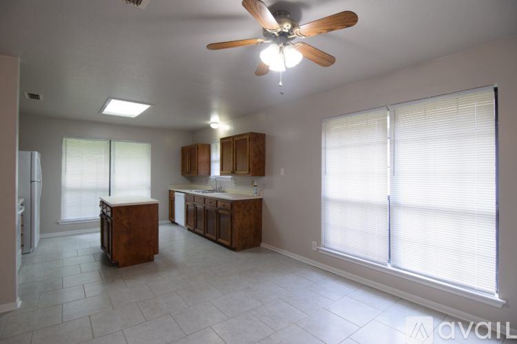 A kitchen with wooden cabinets and a ceiling fan.