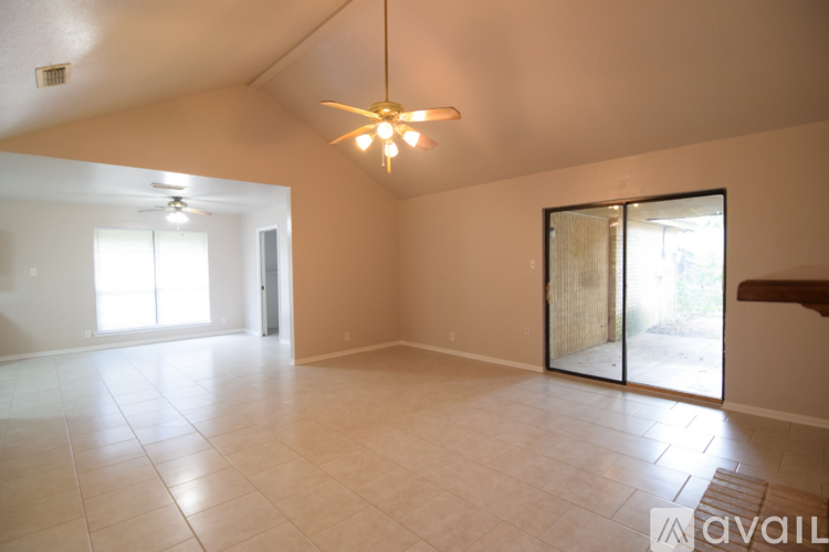 A spacious room with a ceiling fan and a large mirror on the wall.