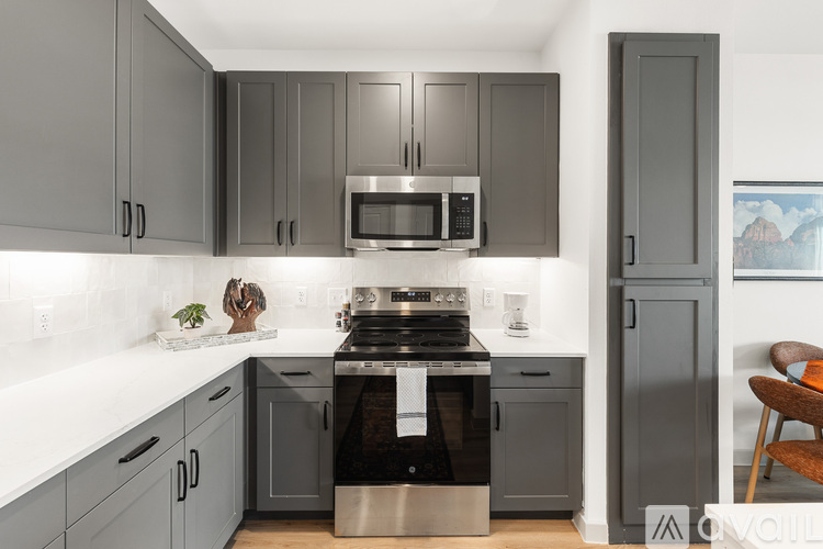 A modern kitchen with a stove top oven and microwave above it.