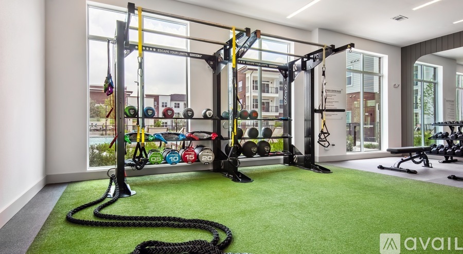 A gym with a green floor and various exercise equipment.