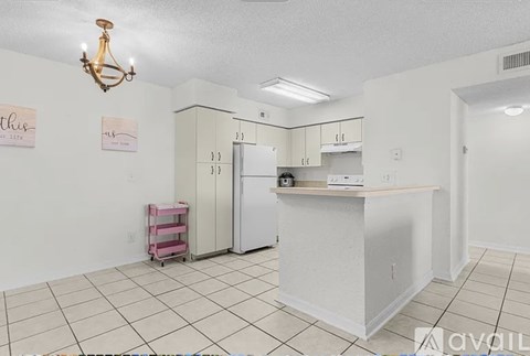 A kitchen with white cabinets and a white refrigerator.
