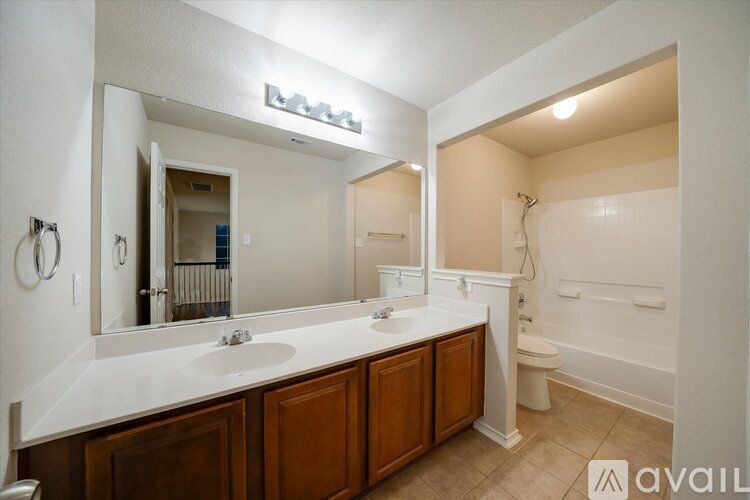 A bathroom with a white countertop and brown cabinets.