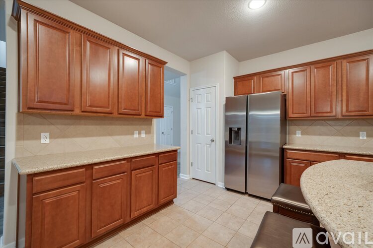 A kitchen with wooden cabinets and a stainless steel refrigerator.