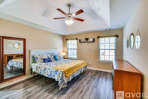 A bedroom with a bed, dresser, and mirror.