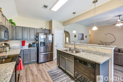 A kitchen with a granite countertop and stainless steel appliances.