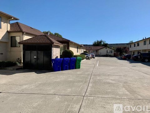 A row of houses with a blue and green dumpster in the foreground.