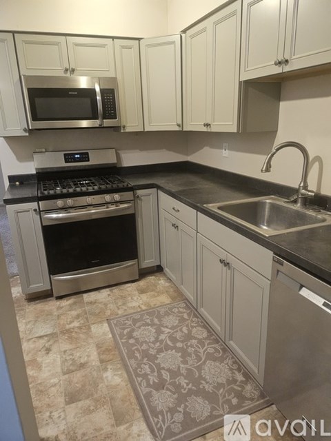 A kitchen with a stove top oven, microwave, and sink.