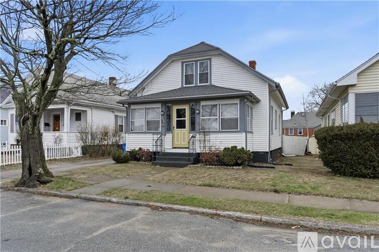 A two-story house with a front porch and a yellow door.