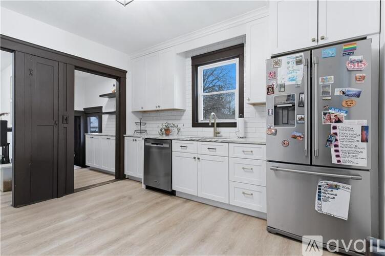 A kitchen with a fridge covered in magnets and notes.