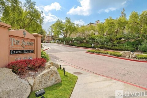 The Summit Rancho Bernardo sign is in front of a tree.