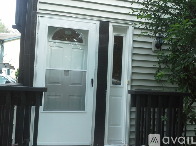 A white door with a glass window is on a house.