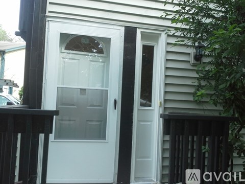 A white door with a glass window is on a house.