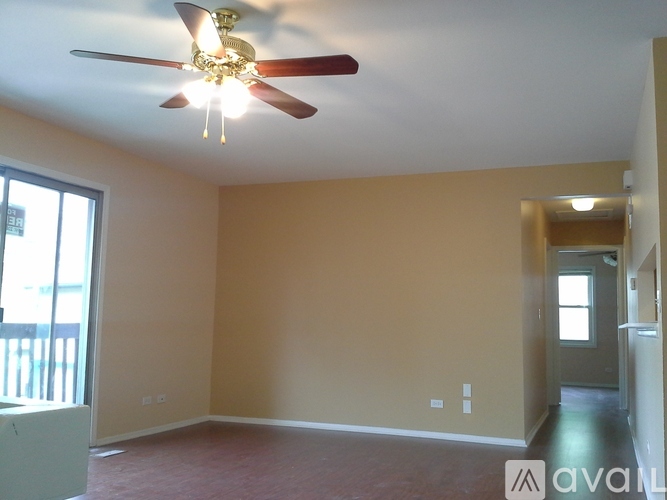 A room with a ceiling fan and a window.