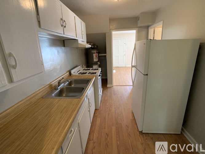 A kitchen with white cabinets and a wooden countertop.