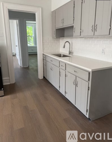 A kitchen with white cabinets and a sink.