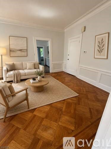 A living room with a white couch and a wooden floor.