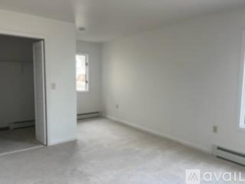 A spacious empty room with a doorway leading to another room.