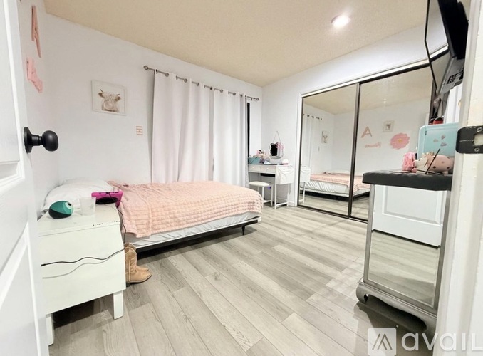 A bedroom with a bed, dresser, and mirror.