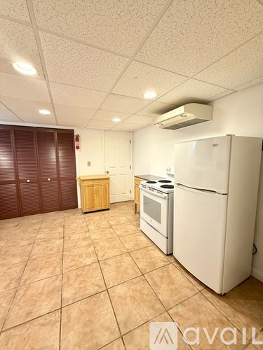 A kitchen area with a white refrigerator, a white oven, and a white stove.