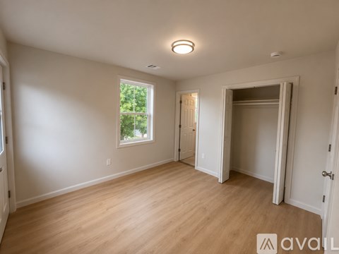A spacious room with wooden floors and white walls.