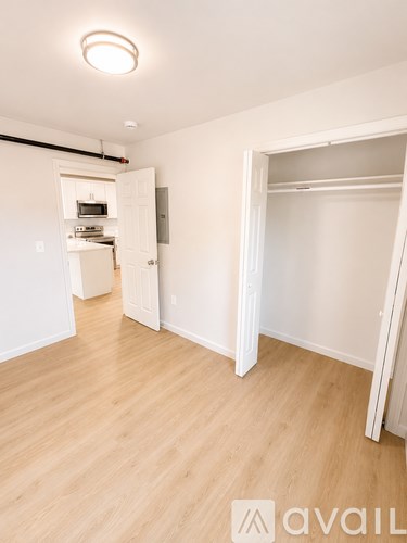 A room with a white door and a white wall with a logo on it.