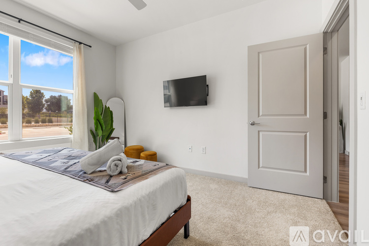 A bedroom with a large bed and a flat screen TV mounted on the wall.
