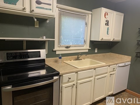 A kitchen with a black stove top oven and white cabinets.